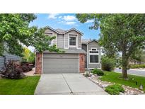 Charming two-story home with a well-manicured lawn, mature trees, and a spacious driveway leading to an attached garage at 11301 Vernon Way, Parker, CO 80134