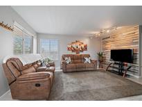 Comfortable living room with brown leather couches, wood accent wall, and neutral decor at 8798 Chase Dr # 4, Arvada, CO 80003