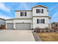 Two-story house with gray trim, two-car garage, and landscaping at 6104 Black Mesa Rd, Frederick, CO 80516