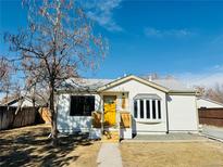 Charming single-story home featuring a bright yellow front door, fresh paint and a well-maintained front yard at 6631 E 77Th Pl, Commerce City, CO 80022