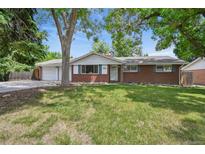 Charming brick ranch-style home with a well-maintained lawn and mature trees providing ample shade at 3784 Swadley St, Wheat Ridge, CO 80033