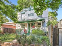 Charming two-story brick home with green accents, lush garden, and inviting front porch at 1612 N High St, Denver, CO 80218