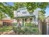 Charming two-story home with a welcoming front porch and vibrant garden, showcasing curb appeal and inviting outdoor space at 1612 N High St, Denver, CO 80218