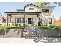 Striking modern home with a white brick facade, black trim, and meticulously landscaped front yard at 1462 S Vine St, Denver, CO 80210
