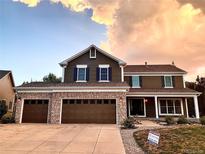 Two-story house showcasing a three car garage with a stone veneer and beautiful curb appeal at 20460 Oakbrook Ln, Parker, CO 80138