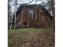 Wooden exterior of the cabin-style home is surrounded by a lush, mature forest at 10314 Red Fern Trl, Conifer, CO 80433