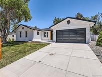 Charming white brick home features a well-kept lawn, a wide driveway, and an attached garage at 3082 S Florence Ct, Denver, CO 80231