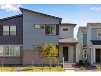 A modern two-story home featuring a stylish gray exterior, well-maintained lawn, and inviting front entrance at 1443 Great Western Dr, Longmont, CO 80501