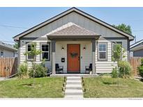 Charming home with a welcoming orange front door and a well-manicured lawn at 4080 Adams St, Denver, CO 80216