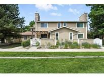 Charming townhome featuring a stone chimney, well-kept lawn, and inviting curb appeal at 8422 Everett Way # C, Arvada, CO 80005