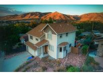 Inviting two-story home featuring a well-maintained lawn and mountain views at 420 Sunshine Pkwy, Golden, CO 80403