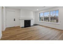Bright living room with wood floors, fireplace, and large windows at 9120 E Girard Ave # 12, Denver, CO 80231