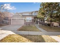 Charming two-story home with a well-manicured lawn, brick accents, and an attached two-car garage at 6483 S Irvington Way, Aurora, CO 80016