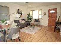 Bright living room features hardwood floors, comfy seating, and large window at 1295 Dayton St, Aurora, CO 80010