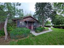 Charming home featuring a well-manicured lawn and mature trees enhancing the curb appeal at 1703 W Weaver Ave, Littleton, CO 80120