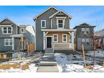 Two-story craftsman style home with gray siding and a white porch at 2068 Chambers Rd, Brighton, CO 80601