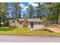 Charming single Gathering home featuring a stone chimney, blue front door, and wooden walkway at 26351 Sheldon St, Kittredge, CO 80457