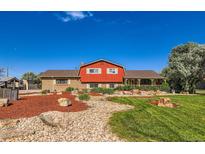 Charming two-story home with unique barn-inspired design, landscaped front yard and inviting porch at 15373 Uravan St, Brighton, CO 80601
