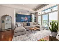 Bright living room featuring a large sectional couch, hardwood floors and lots of natural light at 1488 Madison St # 307, Denver, CO 80206