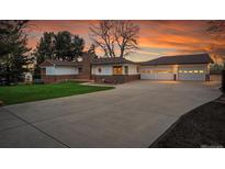 Charming home featuring a three-car garage, brick accents, and a well-manicured lawn, perfect for suburban living at 4095 Field Dr, Wheat Ridge, CO 80033