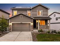 Inviting two-story home featuring a covered porch, stone accents, a two car garage, and solar panels at 2633 Garganey Dr, Castle Rock, CO 80104