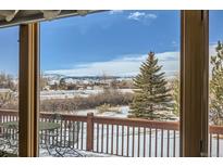 A view from the deck, with an outdoor table and chairs set and a snowy mountainscape in the distance at 1901 Blue Mountain Ave, Berthoud, CO 80513