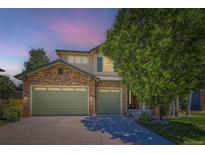 Charming two-story home featuring a stone facade, three-car garage, and mature landscaping at 13962 Dexter Way, Thornton, CO 80602