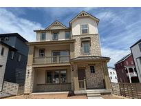 New construction home featuring a stone and siding facade with a covered balcony and a welcoming front porch at 7276 Waterleaf Trl, Littleton, CO 80125
