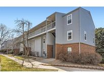 Exterior view of a two-story condo with a sidewalk and green grass at 7665 E Eastman Ave # 210, Denver, CO 80231