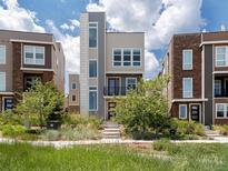 Contemporary three-story home with vertical windows, small balcony, and landscaped front yard at 3654 Penang Dr, Castle Rock, CO 80109