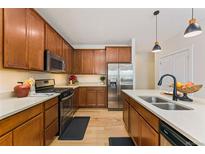 Modern kitchen featuring stainless steel appliances, wood cabinets, and quartz countertops at 671 Robert St, Longmont, CO 80503