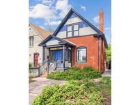Charming two-story brick home with blue accents, a covered porch, and a well-maintained front yard at 434 N Washington St, Denver, CO 80203