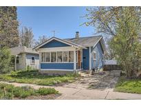 Charming blue home with a sunroom, front yard, and brick driveway, perfect for cozy living at 2252 S Lafayette St, Denver, CO 80210