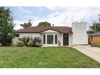 Charming single-story home featuring a well-maintained front lawn, white brick, and beautiful bay window at 2941 Oneida St, Denver, CO 80207