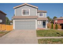 Two-story house with gray siding, attached garage, and landscaped yard at 4184 Netherland St, Denver, CO 80249