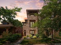 Attractive three-story home featuring a stone facade, a balcony, and manicured landscaping at 2741 Java Ct, Denver, CO 80211