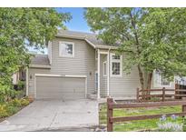 Charming home featuring a two-car garage, light colored siding, and mature trees at 11029 Grouse Ct, Parker, CO 80134