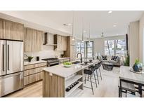 Modern kitchen featuring light wood cabinets, stainless steel appliances, and a spacious island with bar seating at 2323 S High St, Denver, CO 80210
