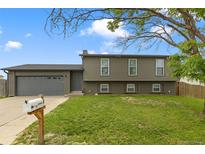 Charming two-story home with a well-maintained lawn and attached garage with a gray exterior elevation at 18396 E Mexico Pl, Aurora, CO 80017