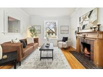 Bright living area with hardwood floors, fireplace, and lots of natural light from a large window at 1748 W 36Th Ave, Denver, CO 80211