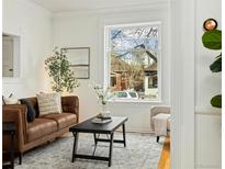 Bright living room with large window, hardwood floors, and comfortable seating arrangement at 1748 W 36Th Ave, Denver, CO 80211
