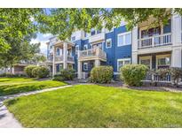 Beautiful blue townhome featuring a well-manicured lawn and private balconies at 9484 E 108Th Ave, Commerce City, CO 80640