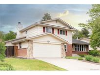 Charming two-story home features a two car garage, stone accents, brick details, and a well-manicured lawn at 7328 S Kit Carson St, Centennial, CO 80122