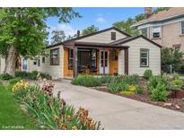 Charming home exterior with colorful flower beds and a cozy front porch at 113 S 4Th Ave, Brighton, CO 80601