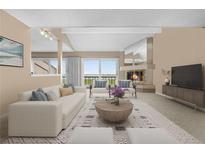 Bright living room featuring a fireplace, access to a balcony, and neutral-toned furniture with a decorative rug at 7160 W Stetson Pl # 27, Littleton, CO 80123