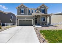 Charming two-story home with a well-manicured lawn and a spacious driveway at 985 Penstemon Dr, Henderson, CO 80640