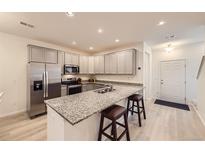 Modern kitchen featuring stainless steel appliances, granite countertops, and light gray cabinetry at 14700 E 104Th Ave # 1404, Commerce City, CO 80022