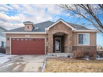 Ranch style home with stone accents and a two-car garage at 6321 Spring Gulch St, Frederick, CO 80516