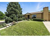 Charming brick home featuring a lush lawn and mature landscaping at 380 E 111Th Pl, Northglenn, CO 80233