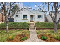 Charming, renovated home with fresh white paint, stone walkway, and mature landscaping at 1220 Magnolia St, Denver, CO 80220